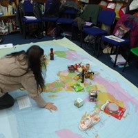 International and global citizenship Woman organising an activity on a large map of the world on the floor