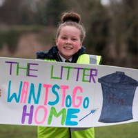 Litter Campaign 2018 - Photo 9 Girl holding a sign which reads "The Litter Wants To Go Home"