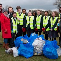 Litter Less Campaign 2018 18 Group of children in high-vis vests stood with adults by bags of collected rubbish