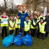 Litter Less Campaign 2018 32 Filbert Fox mascot with his arms around children, posing in high-vis jackets near collected rubbish