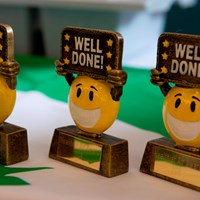 Eco-Schools celebration 30 Smiley face award trophies which say "Well done!"