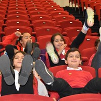 English Martyrs 17 Children from English Martyrs School sitting in an auditorium with their feet up