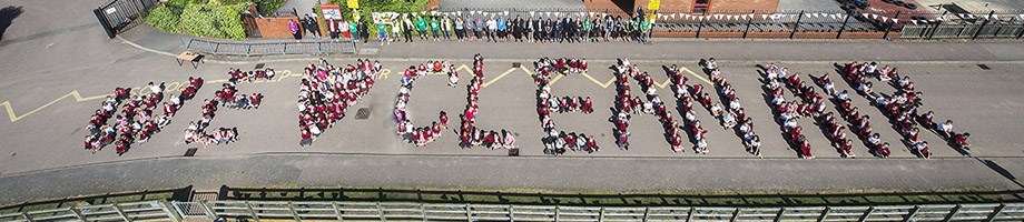 Pupils outside school for an arial photo spelling the words we love clean air